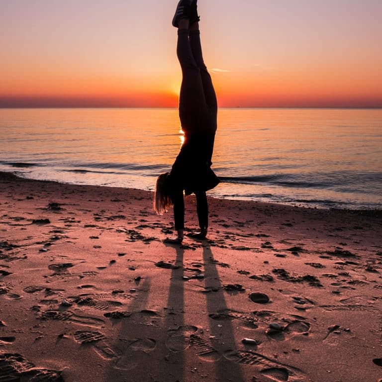 Femme faisant un équilibre sur une plage